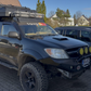 Toyota Black Retro Windshield Banner Decal on black SUV with off-road features and rooftop storage.